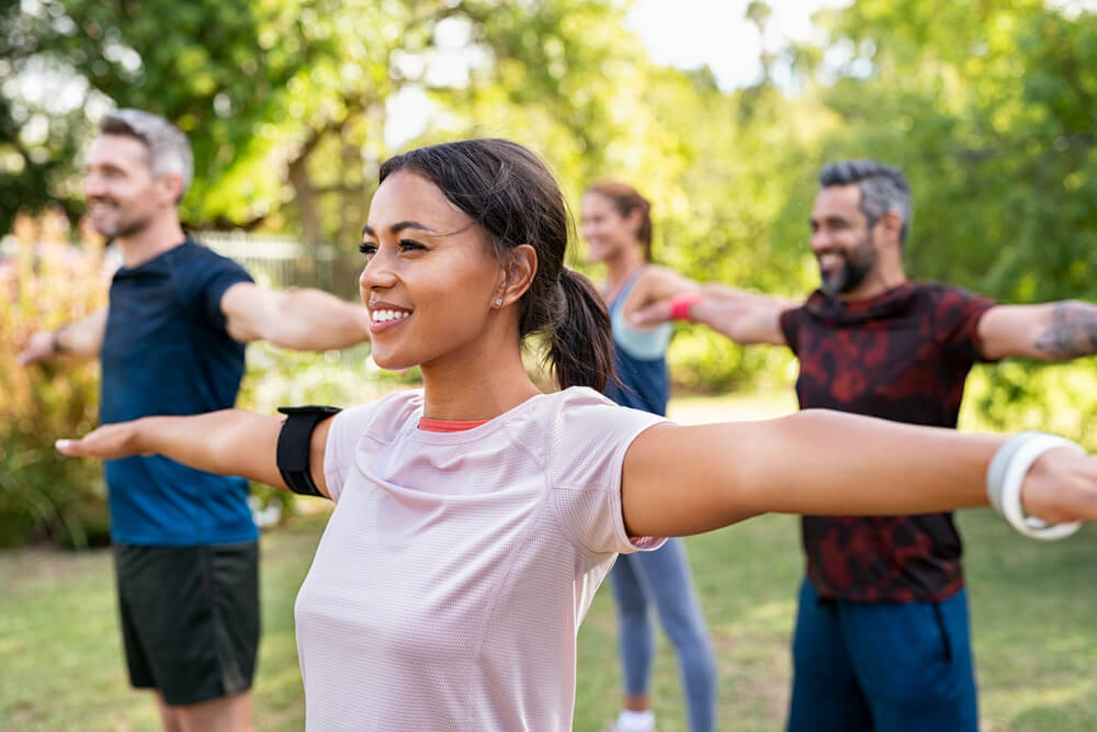 Group of multiethnic mature people stretching arms outdoor. 