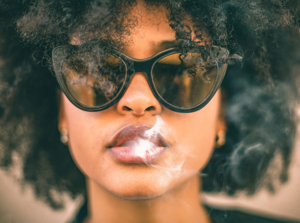 Young African-American woman smoking, up close on smoke and mouth