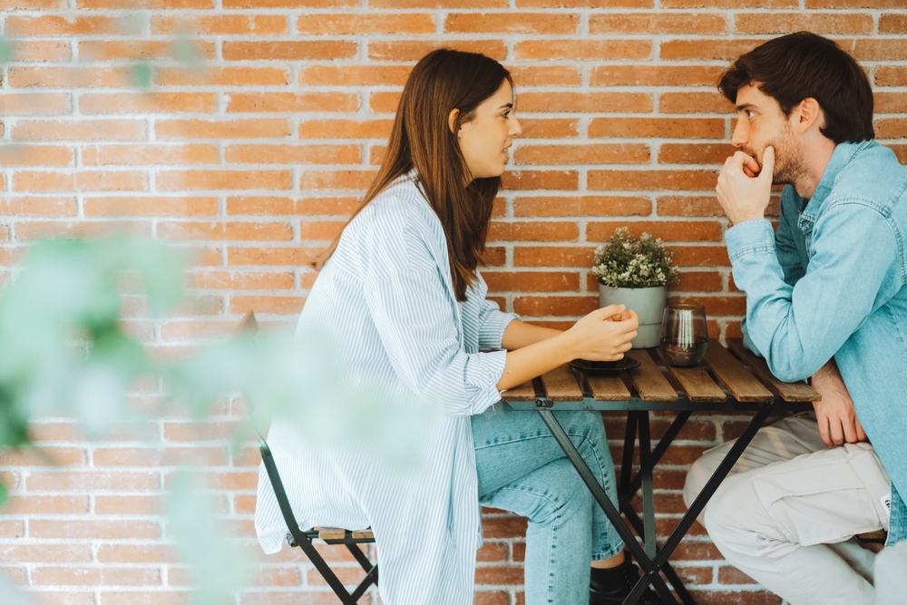 Young couple or friends chatting at home table – friendly conversation