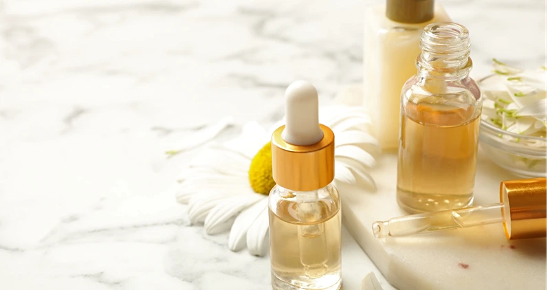 Side-by-side close-up of raw hemp flower next to a small glass vial of CBD isolate crystals on a neutral wood surface, no text overlay, clean product photography style